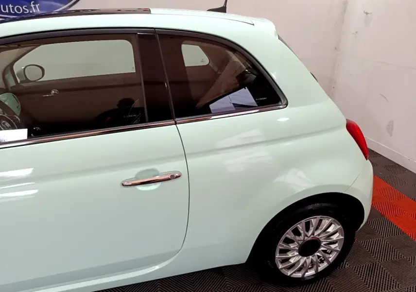 Profil arrière droit d'une Fiat 500 Lounge verte pastel avec jantes alliage et poignée chromée visible.