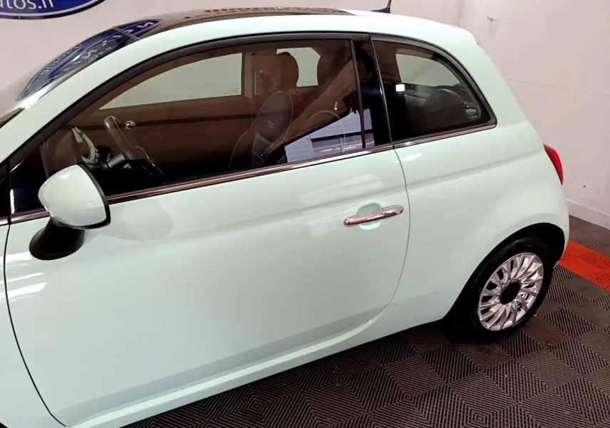 Profil côté gauche d'une FIAT 500 Lounge 2019 vert clair, mettant en valeur la portière et la jante en alliage.