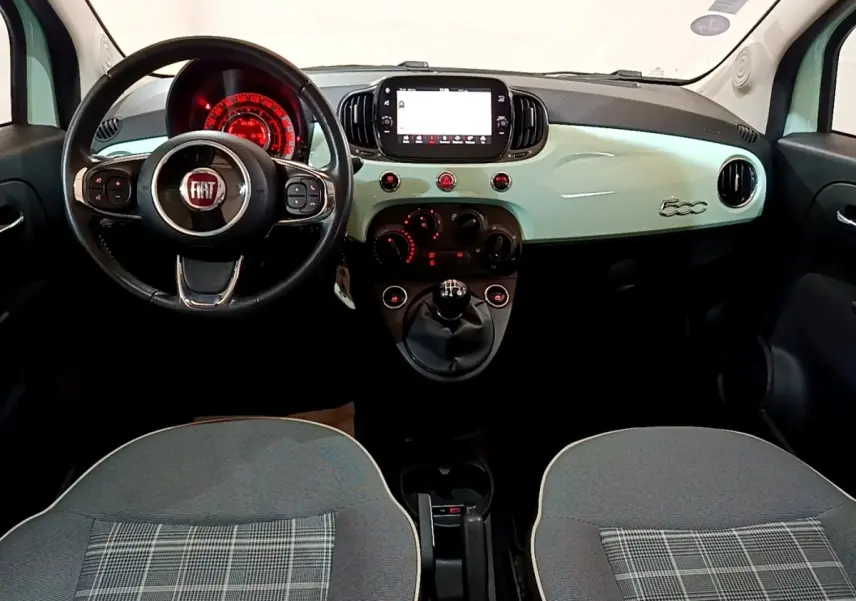 Vue intérieure avant de la FIAT 500 Lounge 2019 avec tableau de bord vert clair et volant cuir multifonctions.