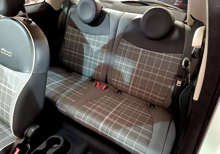 Vue intérieure côté droit sur la banquette arrière à motif à carreaux gris de la Fiat 500 Lounge verte de 2019.