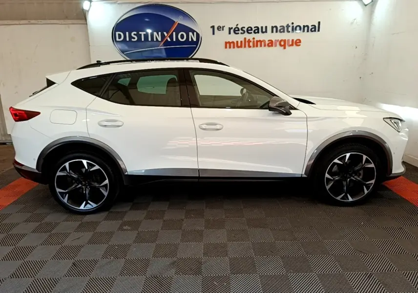 Profil droit d'un CUPRA Formentor blanc 2023 avec jantes noires et logo Distinxion en arrière-plan.