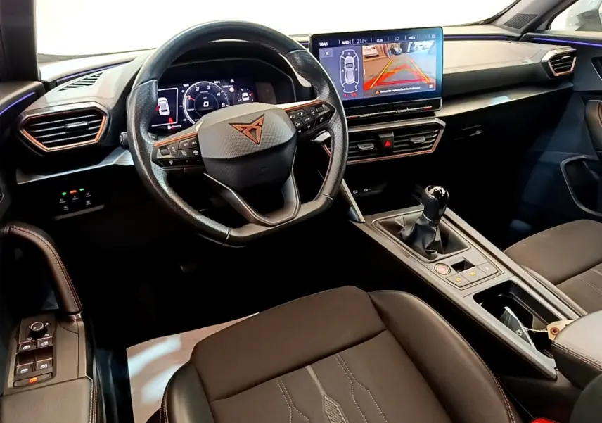 Intérieur noir du CUPRA Formentor 2023 vu côté conducteur, volant cuir, écran tactile et levier de vitesses manuel.