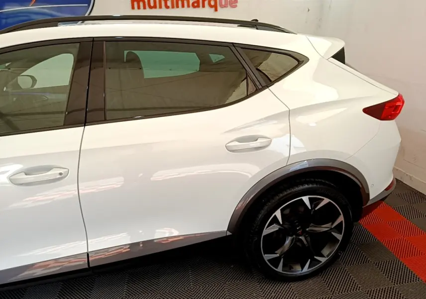 Vue latérale droite du CUPRA Formentor blanc, mettant en valeur la roue arrière noire à jantes stylisées et les lignes de caisse.