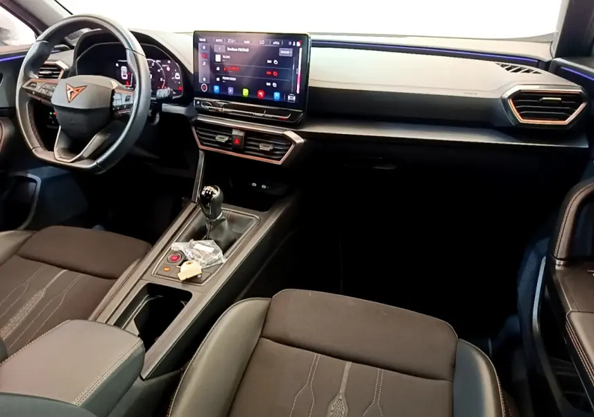 Intérieur avant du CUPRA Formentor 2023, tableau de bord noir avec écran tactile central et volant cuir alu.