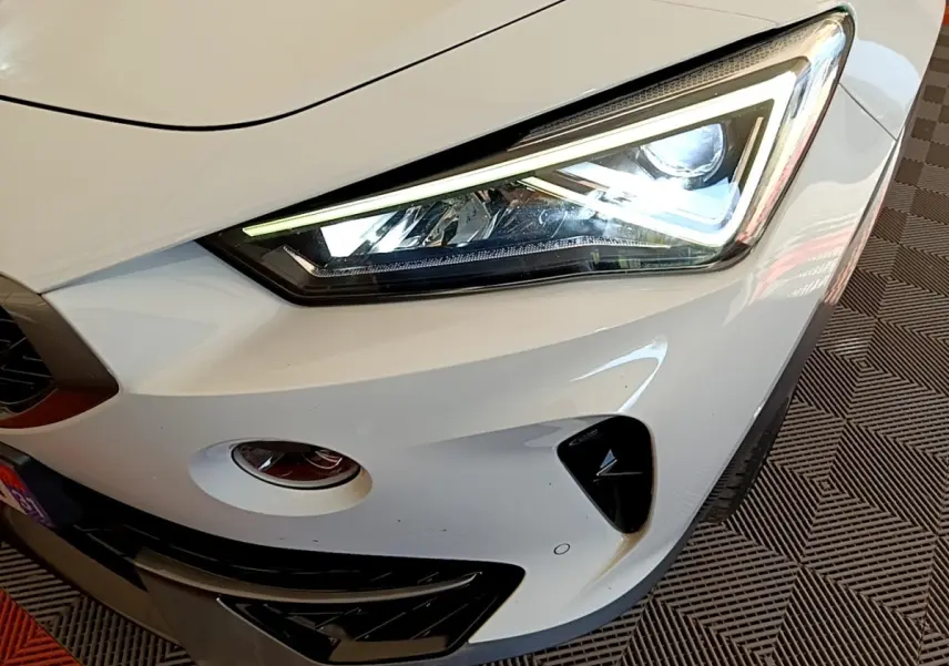 Gros plan sur le phare avant droit blanc du CUPRA Formentor 2023 avec éclairage LED et détails noirs contrastants.