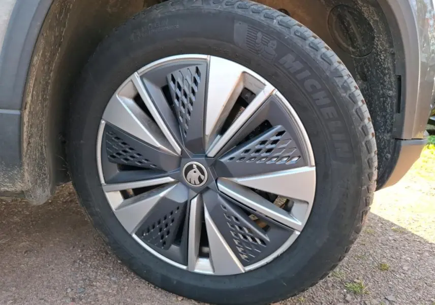 Gros plan sur la jante alu 17'' gris argent avec logo Skoda, montée sur un pneu Michelin d'un Skoda Karoq gris.