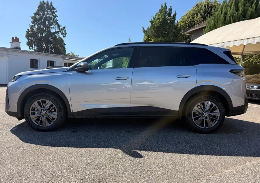 Vue de profil côté gauche d’un Peugeot 5008 gris Artense 2025 avec jantes alliage et vitres teintées.