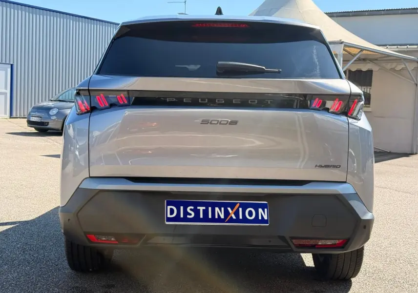 Vue arrière d’un Peugeot 5008 gris Artense hybride 2025 avec feux arrière LED distinctifs et vitrage teinté.