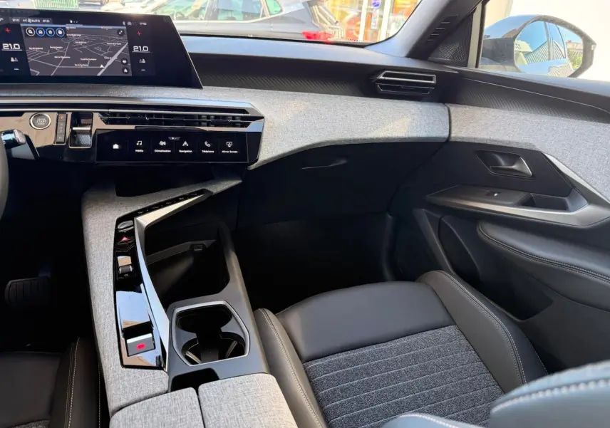 Intérieur du Peugeot 5008 2025 en gris Artense, vue côté passager mettant en valeur la console centrale et l’écran tactile.