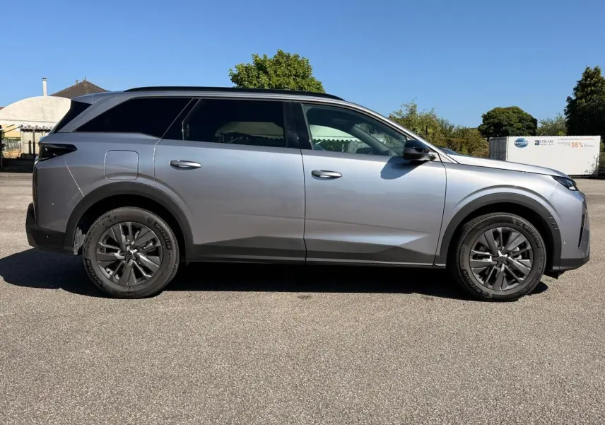 Peugeot 5008 gris Artense vue de profil côté gauche, SUV hybride 2025 avec jantes alliage foncé et toit noir.