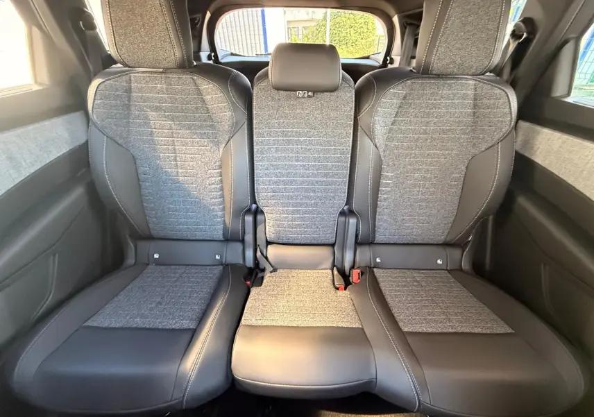 Vue arrière des sièges arrière en tissu gris et cuir noir du Peugeot 5008 1.2 Hybrid 145 Allure 2025.