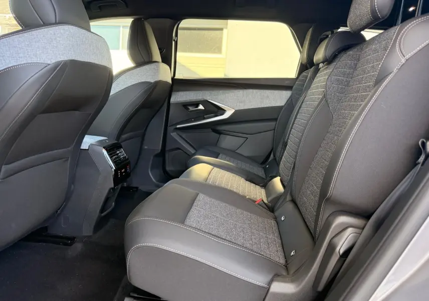 Vue intérieure côté droit des sièges arrière du Peugeot 5008 2025 gris Artense avec sellerie tissu et cuir bicolore.