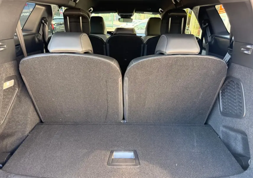 Vue depuis le coffre du Peugeot 5008 gris Artense 2025, montrant les sièges arrière relevés et l'espace de chargement.