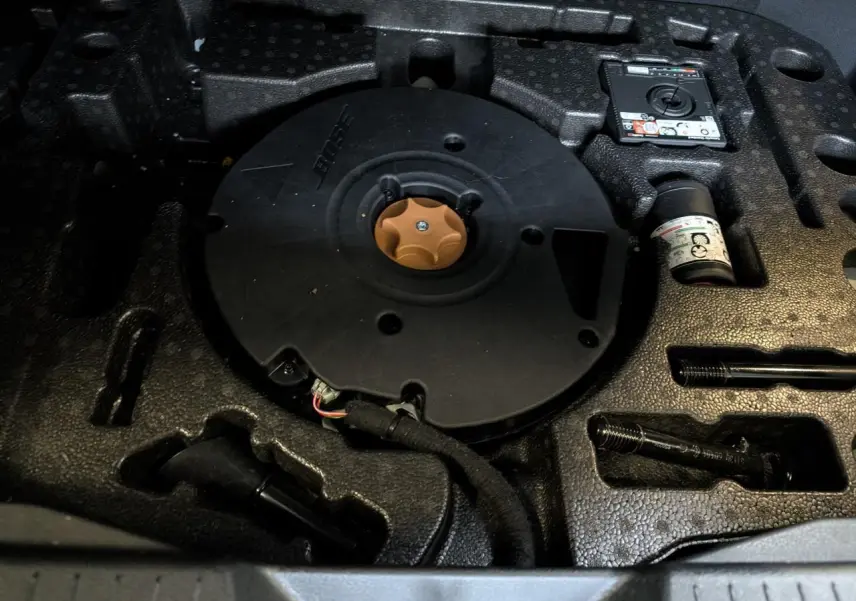 Gros plan sur le coffre avec le caisson de basse Bose intégré sous le plancher du Nissan Qashqai blanc nacré.