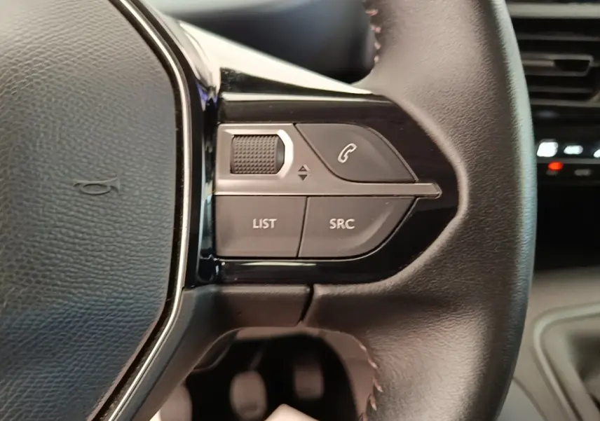 Gros plan sur le volant cuir multifonctions du Peugeot Rifter 2020, avec commandes audio et téléphone intégrées.