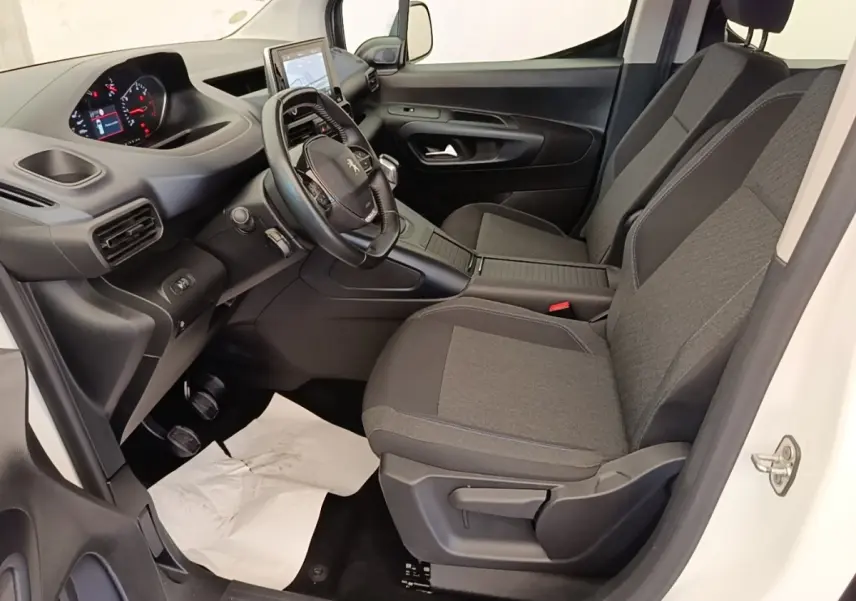 Vue intérieure côté conducteur du Peugeot Rifter blanc 2020, avec volant cuir multifonctions et sièges tissu gris.