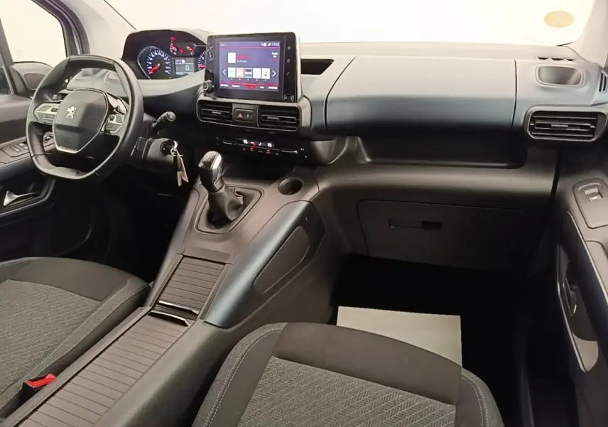 Vue intérieure avant du Peugeot Rifter 2020, tableau de bord noir avec écran tactile et volant cuir multifonctions.