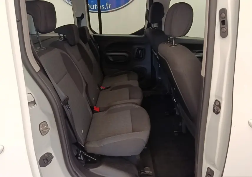 Vue intérieure côté droit sur la banquette arrière trois places du Peugeot Rifter blanc, sièges en tissu gris foncé.
