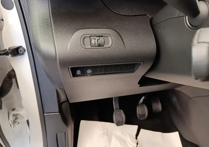Vue intérieure côté gauche du Peugeot Rifter blanc 2020, montrant les commandes d'éclairage et les pédales.