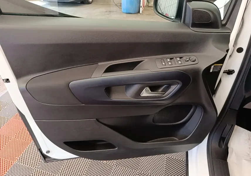 Vue rapprochée de la porte avant gauche blanche du Peugeot Rifter 2020, avec commandes électriques et poignée intégrée.
