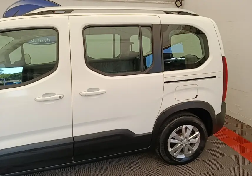 Vue latérale droite d’un Peugeot Rifter blanc 2020 avec portes coulissantes et jantes alliage visibles.