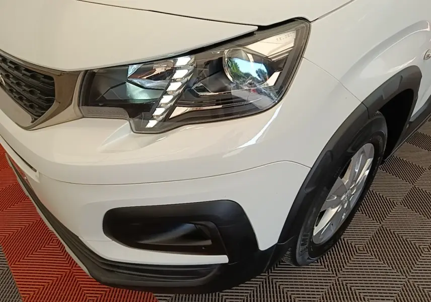 Gros plan sur l'avant droit blanc du Peugeot Rifter 2020, mettant en valeur le phare LED et la calandre noire.