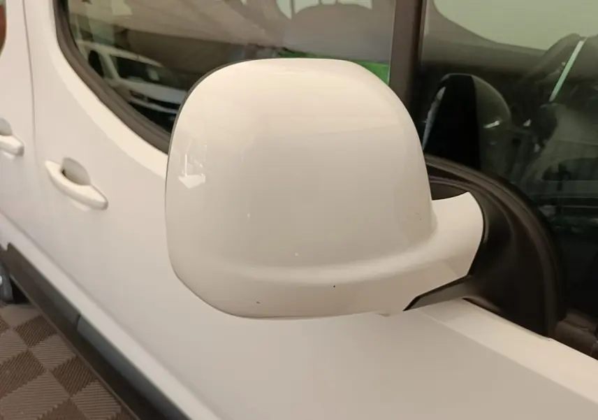Gros plan sur le rétroviseur droit blanc du Peugeot Rifter 2020, avec porte et fenêtre arrière visibles.