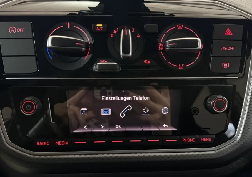 Tableau de bord de Volkswagen Up 1.0 65 Active 2022 avec commandes climatisation et écran tactile central allumé.