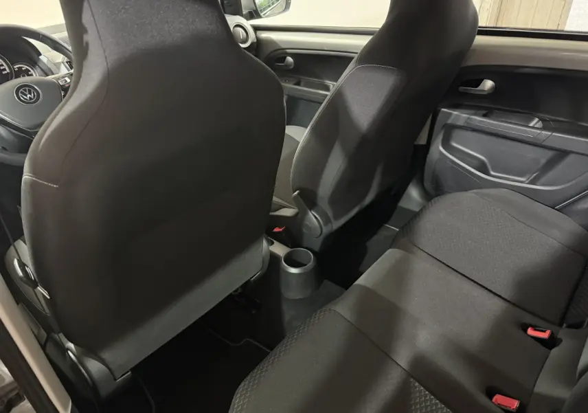Vue intérieure arrière du Volkswagen Up 1.0 65 Active 2022, sièges tissu noir et console centrale compacte.