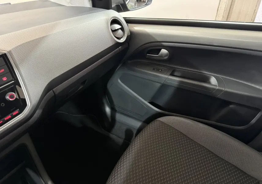 Intérieur côté passager de la Volkswagen Up 1.0 65 Active 2022, montrant la porte et tableau de bord gris foncé.