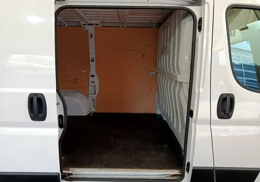 Vue latérale droite du fourgon blanc FIAT Ducato 2.3 Multijet 120 avec porte coulissante ouverte sur l’espace de chargement vide.