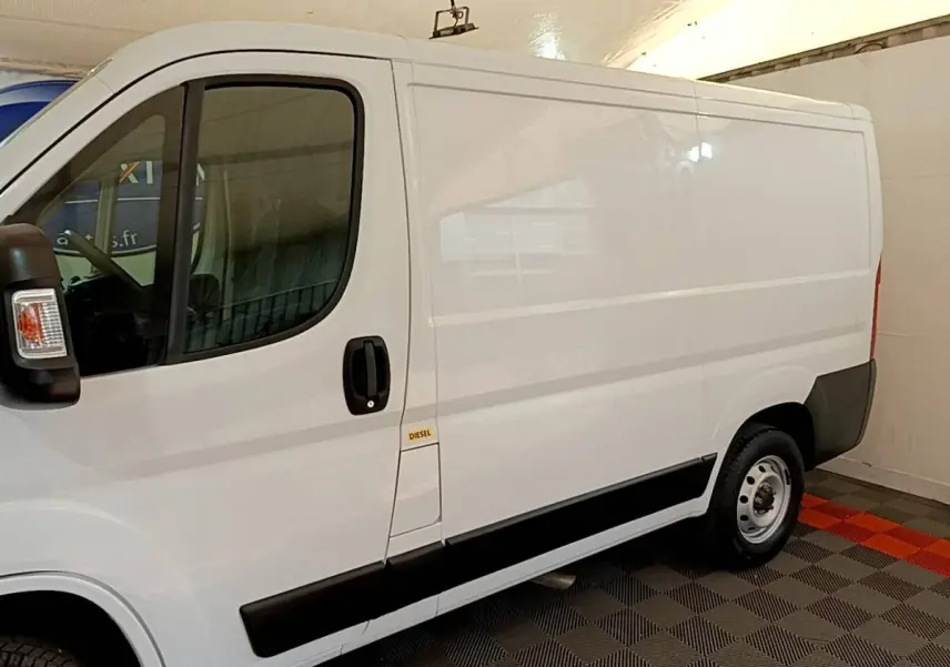 Vue de profil côté gauche d’un fourgon FIAT Ducato blanc 2021 avec bande noire latérale et marquage Diesel.
