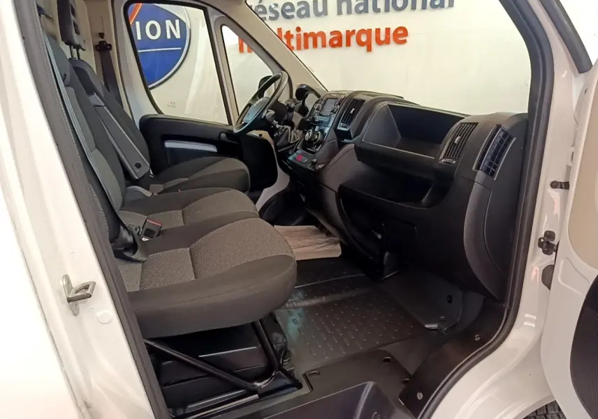 Intérieur du FIAT Ducato Fourgon blanc 2021 vu côté droit, montrant les sièges avant et le tableau de bord noir.