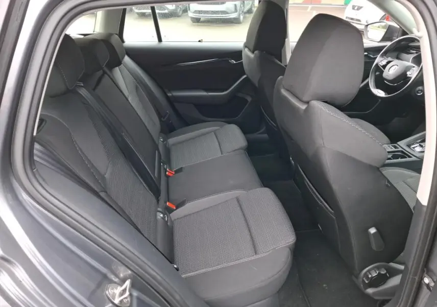Vue intérieure côté gauche de la banquette arrière noire du Skoda Octavia Combi 2023 avec sièges tissu et appuie-têtes.