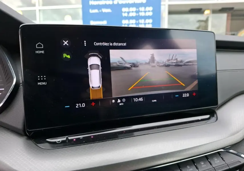Écran tactile intérieur de la Skoda Octavia Combi gris montrant l’aide au stationnement avec caméra de recul.