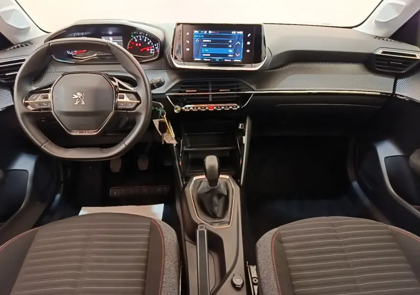 Vue intérieure avant de la Peugeot 208 PureTech 75 S&S Active Pack 2023, volant cuir multifonctions et écran tactile central.