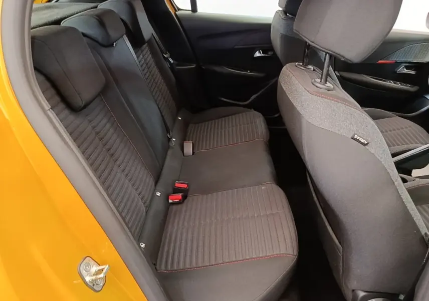 Vue intérieure arrière côté gauche de la Peugeot 208 jaune 2023, banquette tissu noir avec surpiqûres rouges.