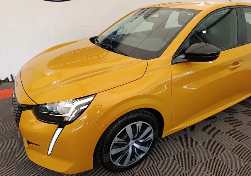 Vue 3/4 avant droit d'une Peugeot 208 jaune vif avec phares LED et rétroviseurs noirs brillants.