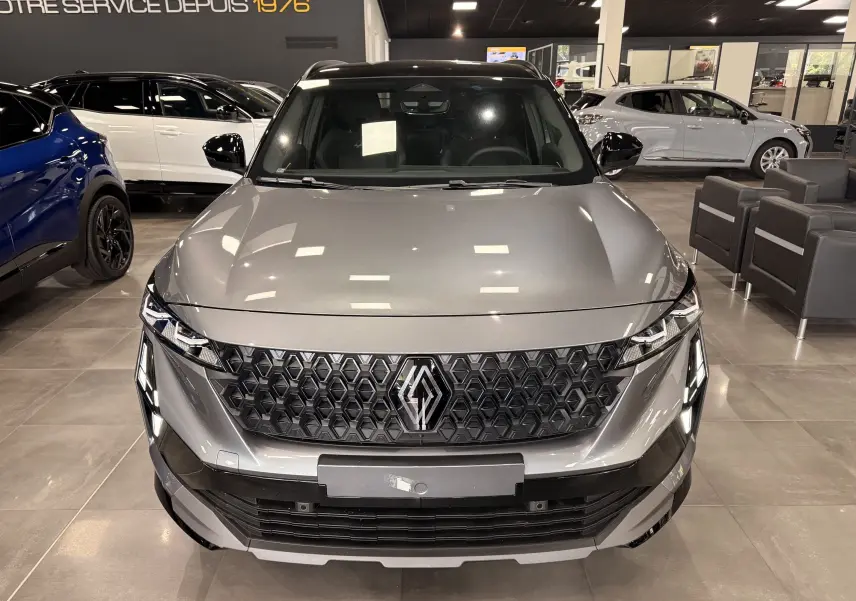 Vue avant d’un Renault Austral gris schiste avec toit noir, mettant en valeur sa calandre hexagonale et ses phares LED distinctifs.