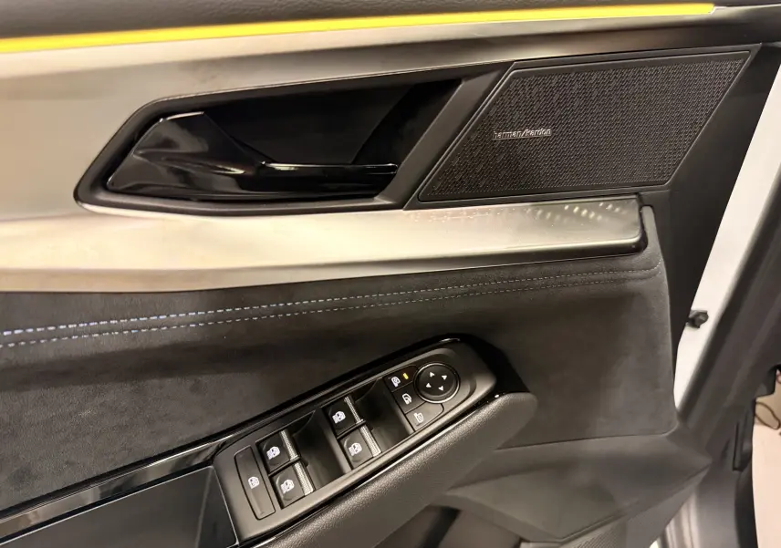 Détail de la porte avant gauche du Renault Austral 2026 gris Schiste, avec commandes de vitres et haut-parleur Harman/Kardon.