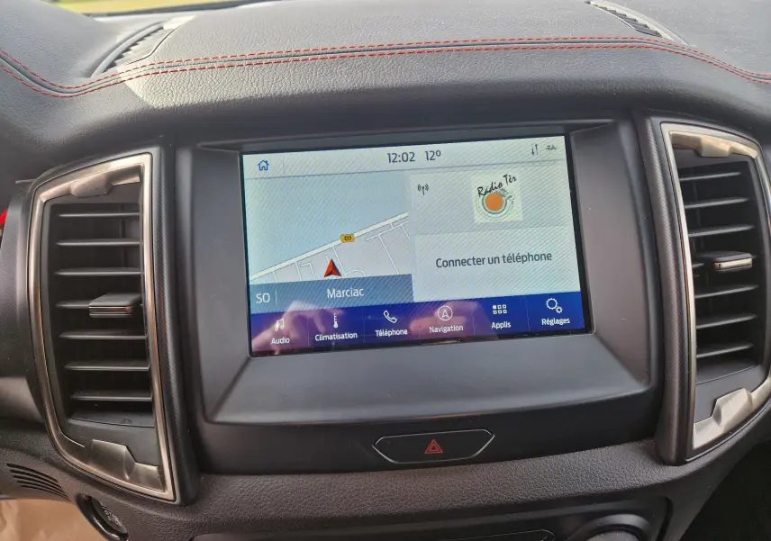 Écran tactile central du Ford Ranger Raptor 2022 avec navigation et tableau de bord en cuir noir surpiqué rouge.