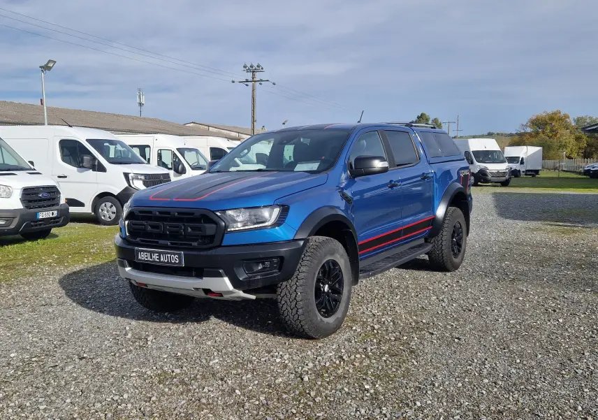 Ford Ranger Raptor bleu Ford Performance vu en 3/4 avant droit, avec hard top et marquages rouges sur capot et flancs.