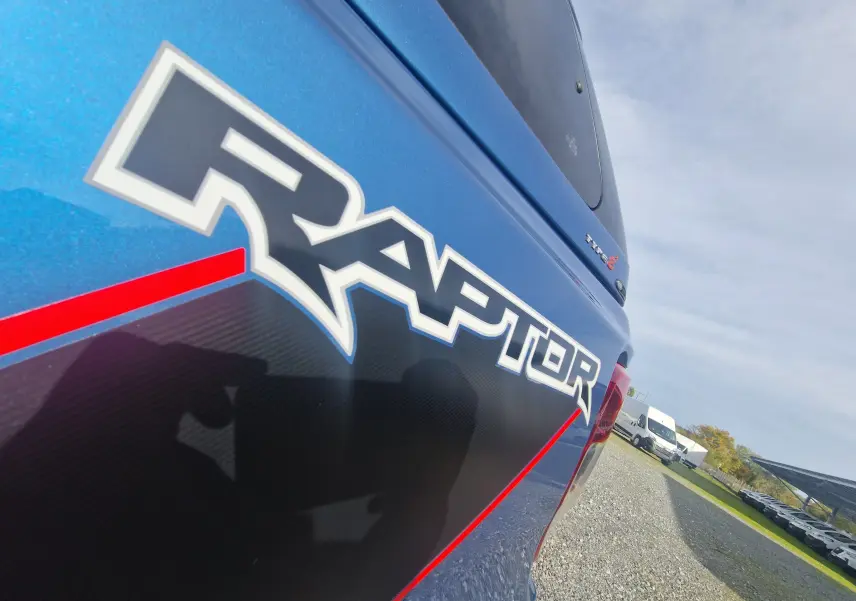 Gros plan sur l'arrière droit bleu Ford Performance du Ford Ranger Raptor 2022 avec logo Raptor et hard top visible.