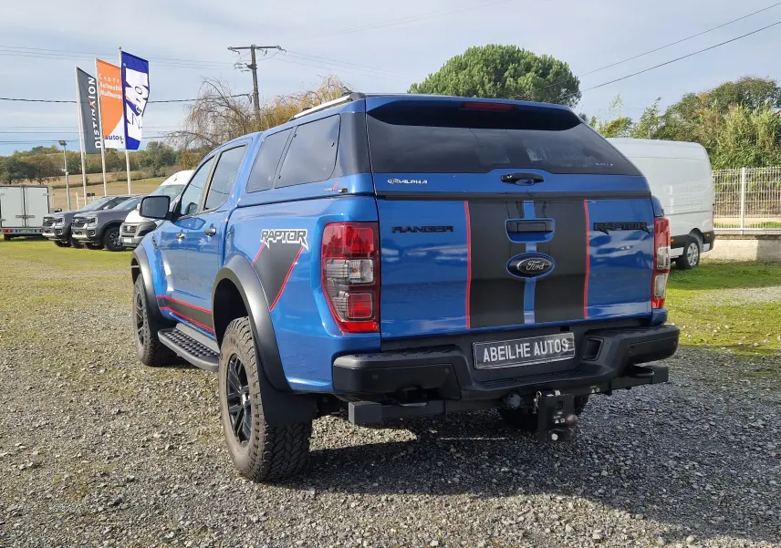 Ford Ranger Raptor bleu Ford Performance vu en 3/4 arrière droit avec hard top et bandes noires rouges.