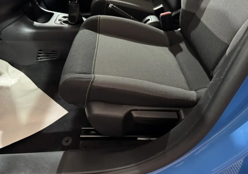 Gros plan sur le siège avant droit gris foncé avec surpiqûres jaunes dans une Citroën C3 bleu 2018.
