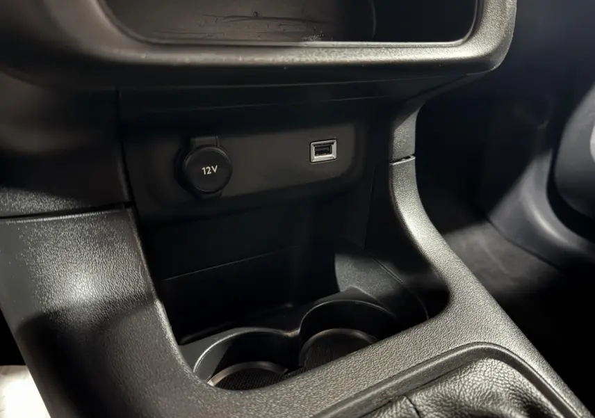Prise 12V et port USB en gros plan sur la console centrale noire d'une Citroën C3 bleu 2018.