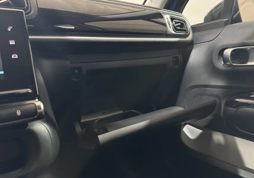 Intérieur de la Citroën C3 2018, vue du côté passager montrant la boîte à gants ouverte et la porte noire.