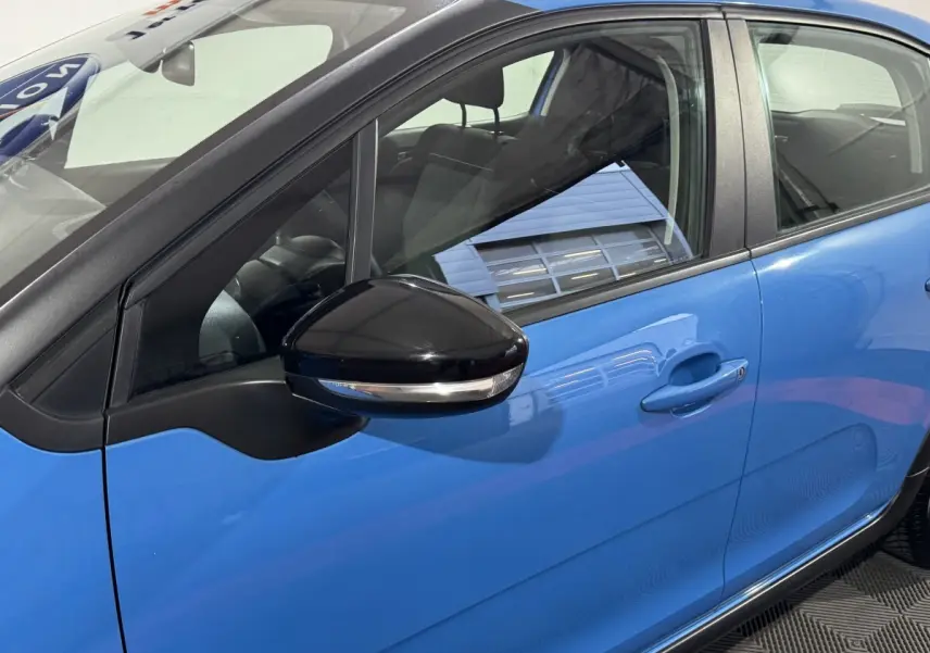 Vue latérale côté gauche d'une Citroën C3 bleu avec rétroviseur noir brillant et poignées de porte ton caisse.