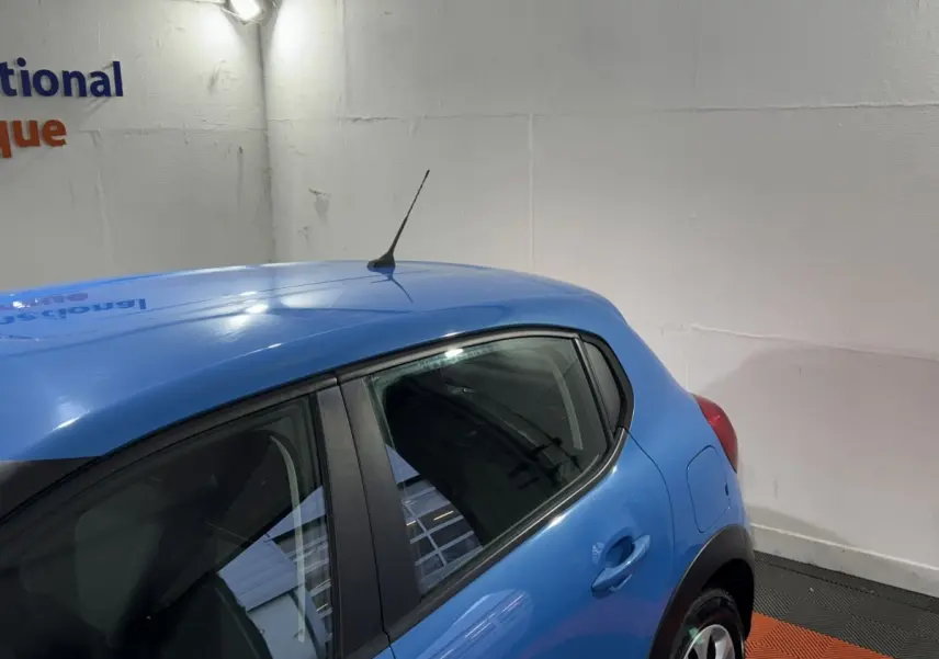Vue côté arrière droit d'une Citroën C3 bleu vif avec antenne de toit et poignées de porte ton caisse.
