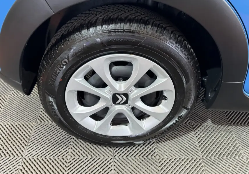 Gros plan sur la roue avant droite d'une Citroën C3 bleu 2018 avec jante argentée et logo Citroën central.